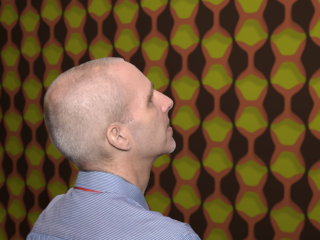 side view of Andy Giger looking at a repeat pattern mural